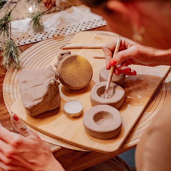 A cozy clay crafting session with small figures in progress, surrounded by pottery tools using Sculpd Pottery Kit